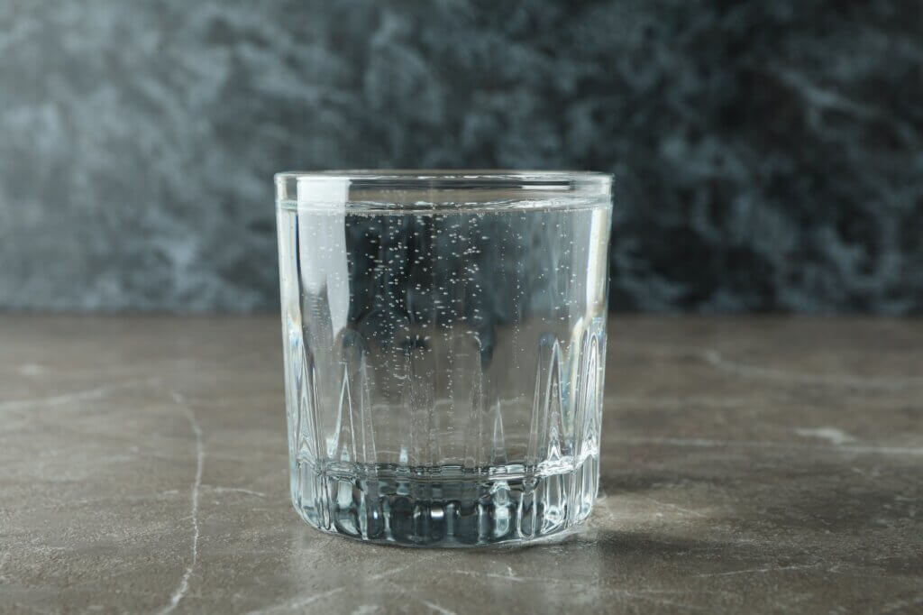 Glass of mineral water on gray table