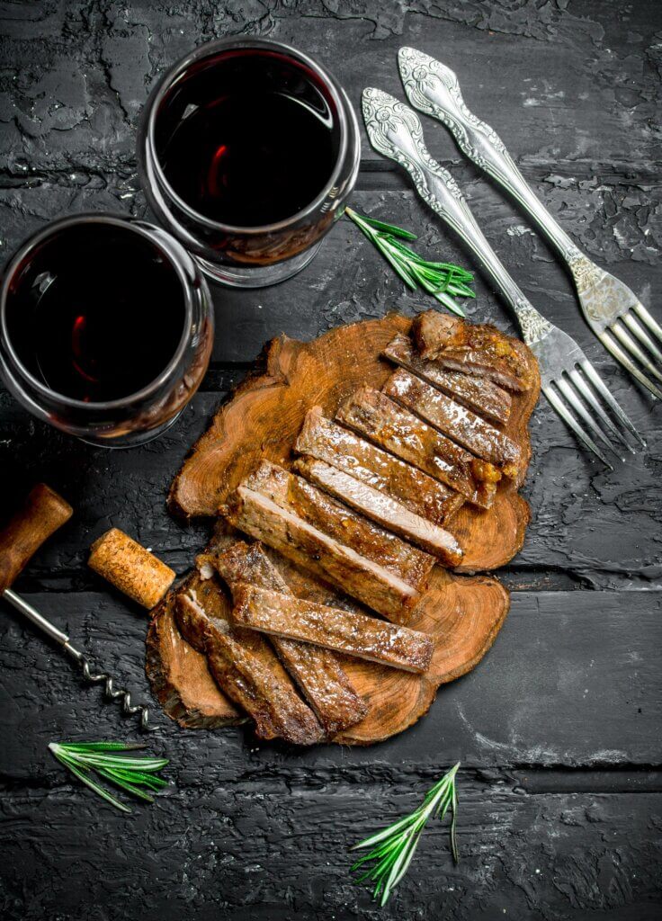 Sliced grilled steak with wine.